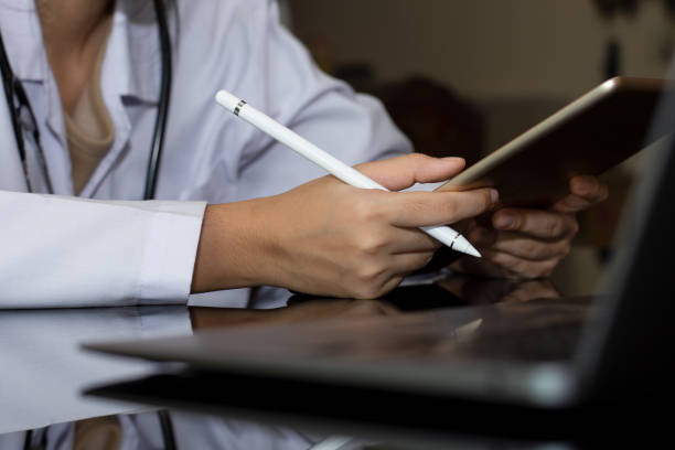 istock Doctorusing digital tablet and work with laptop computer. 
 Telehealth, meditech, telemedicine concept. 1350217435