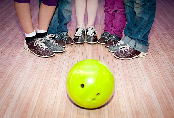 istock Five people surrounding a bright yellow bowling ball 135021821