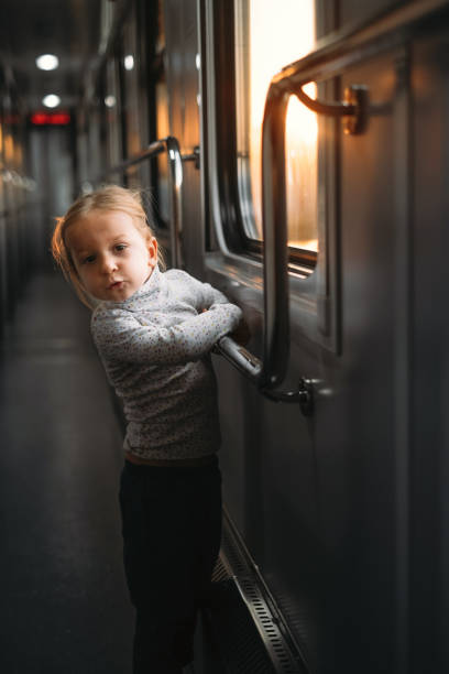 istock Girl, child looking though train window on sunset 1350221369