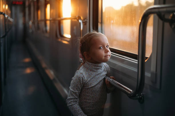 istock Girl, child looking though train window on sunset 1350221509