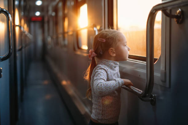 istock Girl, child looking though train window on sunset 1350222575