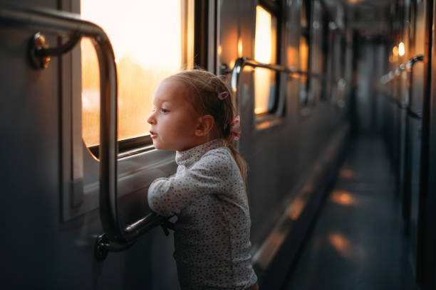 istock Girl, child looking though train window on sunset 1350223152