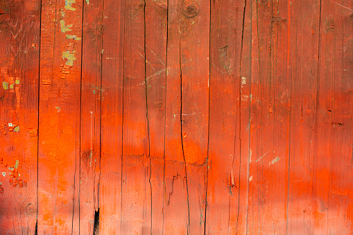 The texture of the red board. Painted garage door. Details of the gate with old paint.