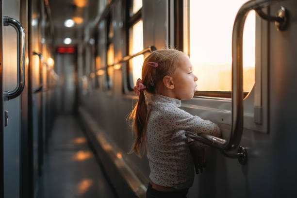 istock Girl, child looking though train window on sunset 1350223197