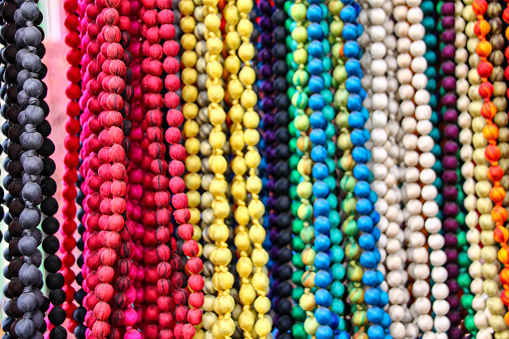 Close up of brightly colored boho bead necklaces hanging on display