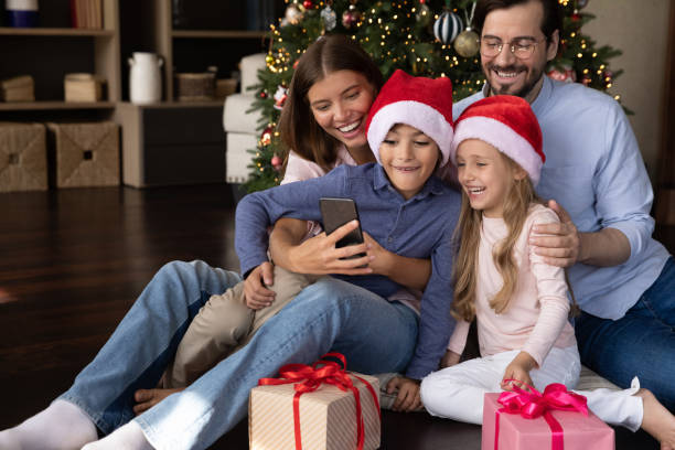 istock Happy bonding young couple parents and small kids using cellphone. 1350227480