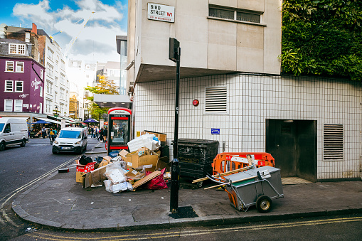 London, UK - 27 October, 2021: piles of rubbish discarded on a city street in central London, UK.