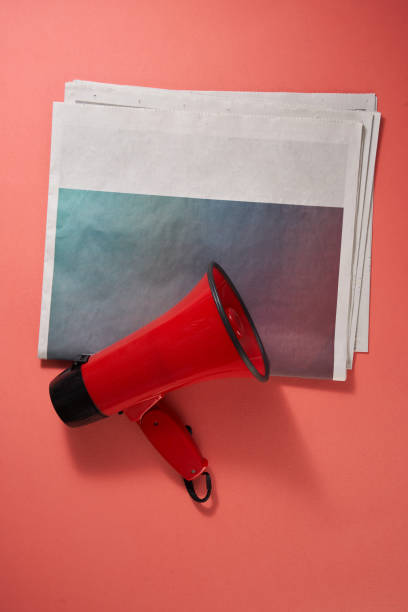 赤の背景に新聞とメガホン - newspaper article advertisement the media ストックフォトと画像