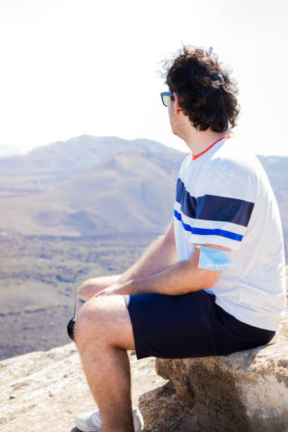 istock Traveler resting on the top of a mountain while looking the scenery. 1350231996