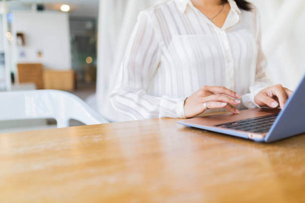 istock Asian woman working on laptop with white screen in modern office. 1350234985