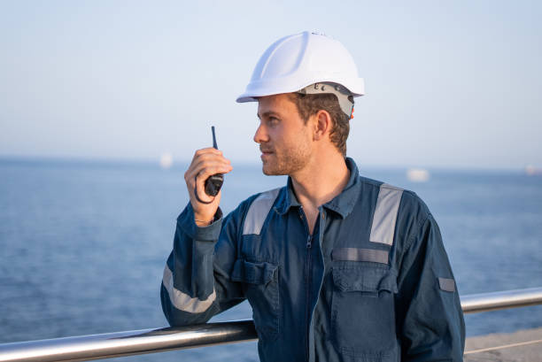 istock Workman talking on walkie talkie near sea 1350237835