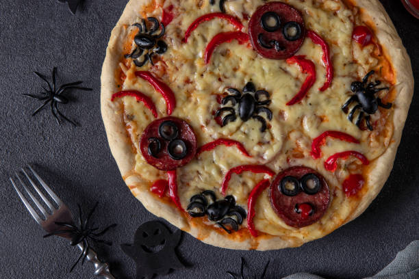 istock Halloween funny pizza with spiders, Creative idea for Halloween pizza on dark gray background, Top view 1350239300