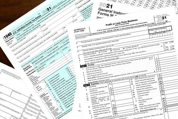 2021 IRS tax forms Various 2021 IRS tax forms on a wood desktop. tax stock pictures, royalty-free photos & images