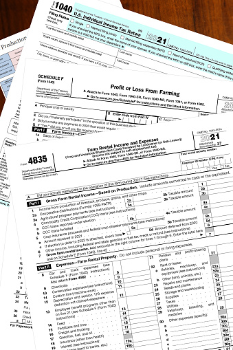 Blank 2021 IRS tax forms on a wooden desktop.