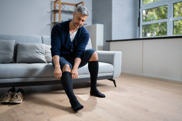 istock Man Putting On Medical Compression Stockings 1350239776
