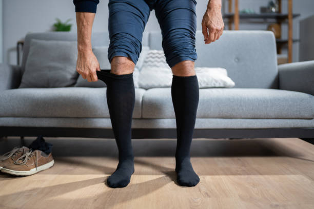 istock Man Putting On Medical Compression Stockings 1350239780