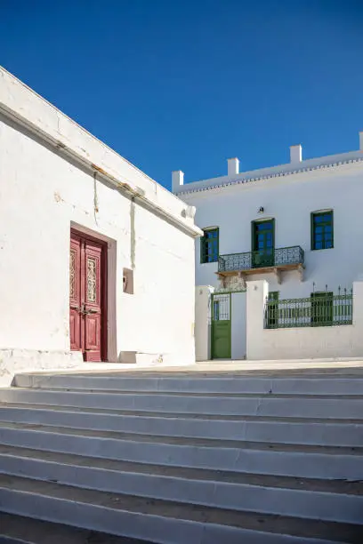 Traditional residential neighborhood Cyclades architecture whitewashed houses empty stone stairs blue sky sunny day at Kythnos island, Chora summer destination Greece. Vertical