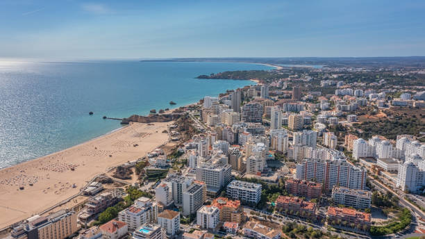 Aerial view of the city of Portimao over residential buildings, high-rise buildings, on the beach Praia de Rocha with tourists. stock photo