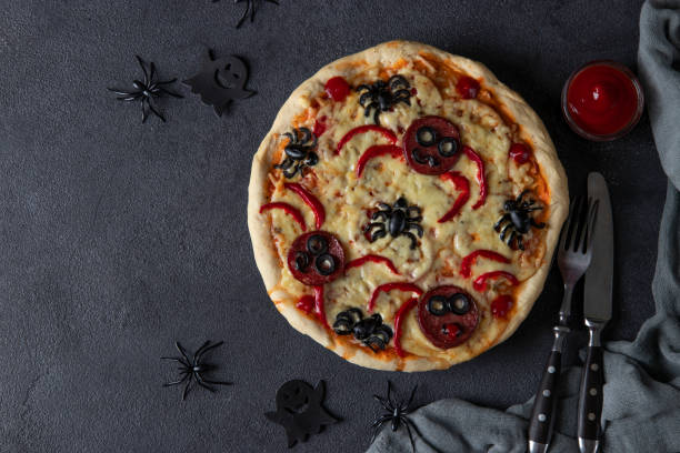 istock Halloween funny pizza with spiders, Creative idea for Halloween pizza on dark gray background, Top view 1350241102