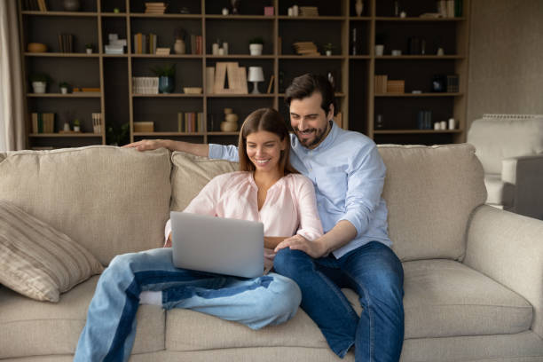istock Happy young family couple using computer at home. 1350241358