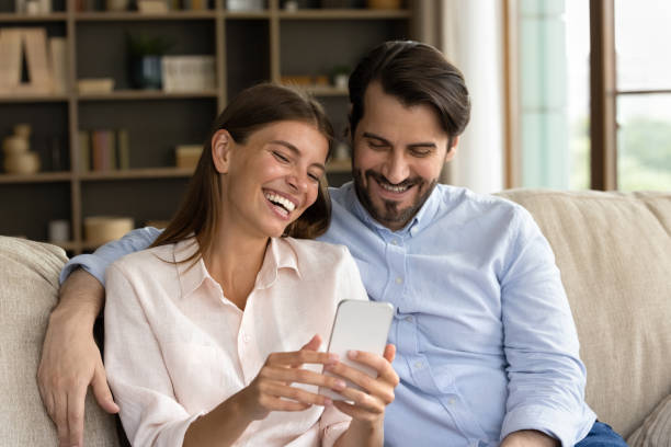 istock Happy young family couple using cellphone at home. 1350241359