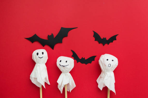 istock Halloween flat lay - bats and ghosts on red background. 1350241743