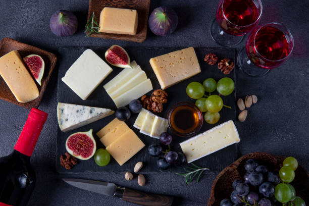 istock Cheese varieties, grapes, figs and nuts on a slate plate. Wine snacks for a holiday party. View from above 1350244679