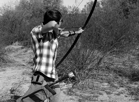 Young archer shooting a traditional long bow