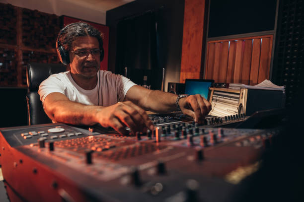 istock Senior hispanic music producer working on a mixing soundboard while in his studio 1350248766