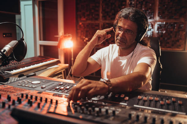 istock Senior hispanic music producer working on a mixing soundboard while in his studio 1350248771