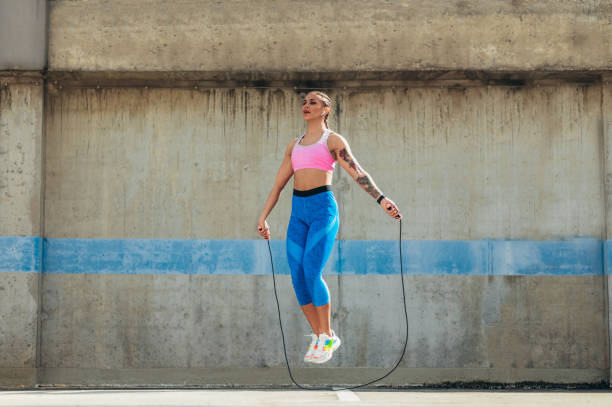 istock Attractive young woman using a fitness jump rope while training outside 1350249490