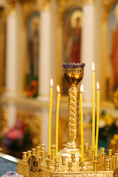 istock Candlestick in church, burning candles fire, cathedral interior 1350255908