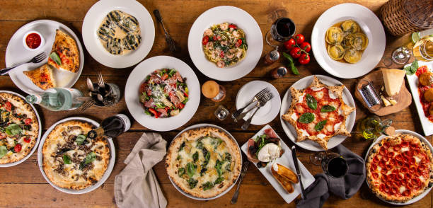 grande tavolo da pranzo con cibo italiano, pizze e pasta - cibo italiano foto e immagini stock