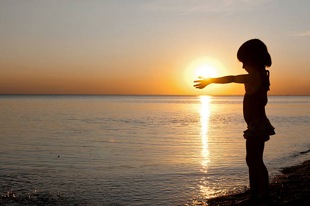 istock Child silhouette on sunset beach 135026212