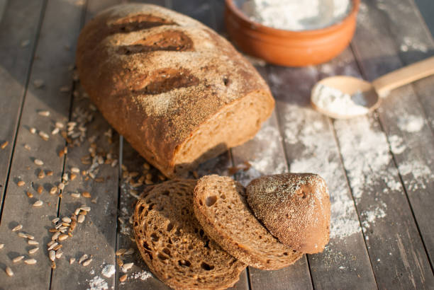 istock Black bread on a rustic wooden table with slices of bread 1350263148