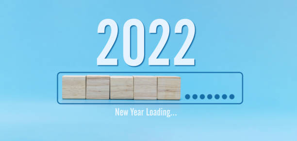 istock Loading new year 2022. number written on wooden cube block stack on blue background, change from 2021 to 2022, congratulation, happy new year, countdown to 2022, goal and target plan concept 1350263234