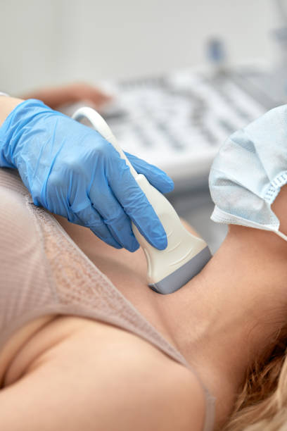 woman getting ultrasound of a thyroid from doctor stock photo