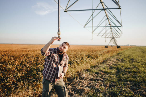 istock Young farmer standing in wheat field and setup irrigation system 1350272240