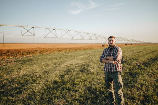 istock Young farmer standing in wheat field and setup irrigation system 1350273480