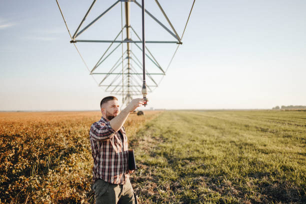 istock Young farmer standing in wheat field and setup irrigation system 1350275626