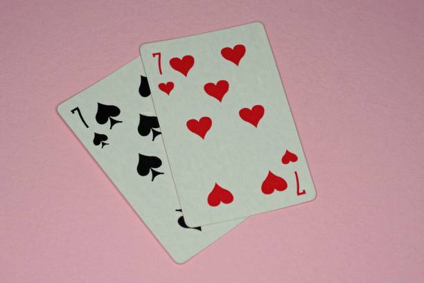 istock playing cards of sevens lie on a pink table 1350276835