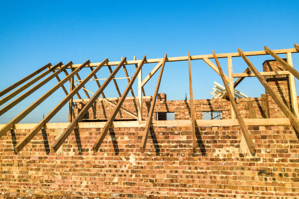 istock Unfinished brick house with wooden roof structure under construction. 1350279998