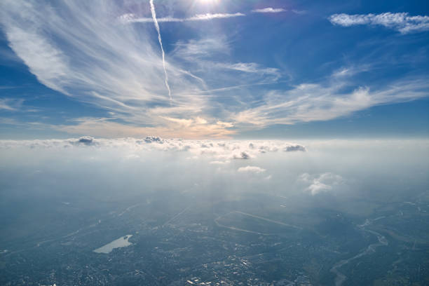 istock Aerial view from airplane window at high altitude of earth covered with white thin layer of misty haze and distant clouds. 1350280067