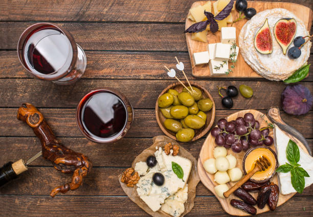istock Various type of cheese grapes dates olives nuts fig and wine  on wooden background. 1350281684