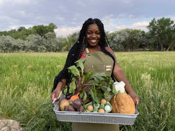 Portrait of a Happy Young African American Woman Standing at the Door of a Walk-In Refrigerator Holding a Basket of Delicious, Healthy, Organic Produce at a Local Small Business Farm-to-Table Supplier in Colorado retrato de una joven afroamericana feliz de pie en la puerta de un refrigerador sin cita previa sosteniendo una canasta de productos deliciosos, saludables y orgánicos en un proveedor local de pequeñas empresas de la granja a la mesa en colorado