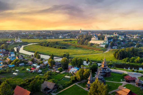 Aerial drone view of Suzdal Kremlin and cathedral of Nativity with Museum of Wooden Architecture at the Kamenka river, Russia. Summer sunny day sunset.