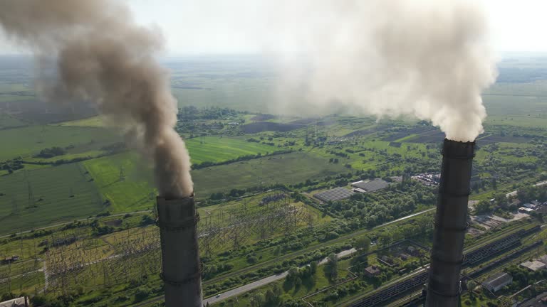 Aerial view of coal power plant high pipes with black smokestack polluting atmosphere. Electricity production with fossil fuel concept