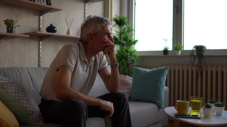 Man sitting alone at home looking sad and distraught