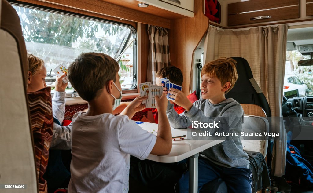 Children playing cards in a caravan Motor Home Stock Photo