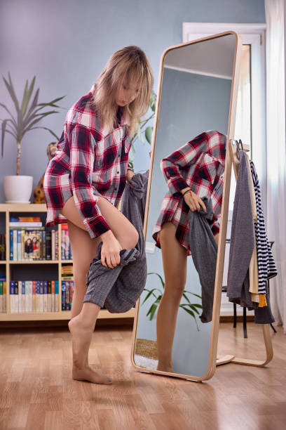 istock Large full length standing mirror and female changes pants near it. 1350318914
